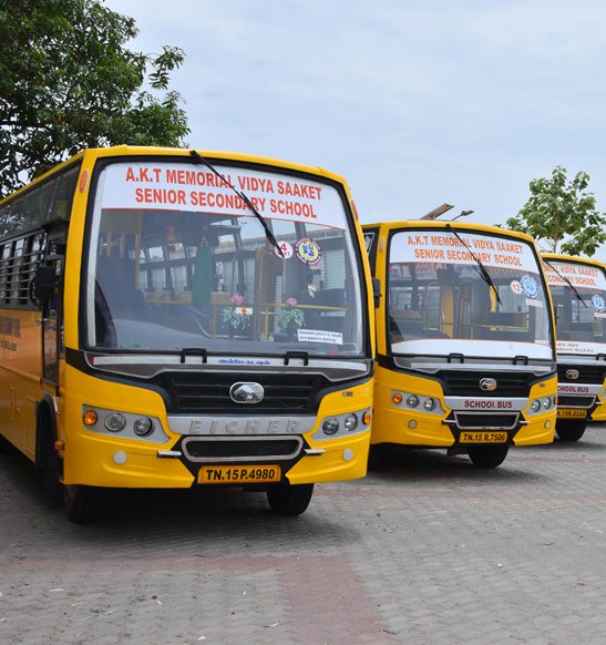 Yellow AKT school buses parked on campus